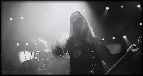 Man With Long Hair Playing Bass Guitar on Stage