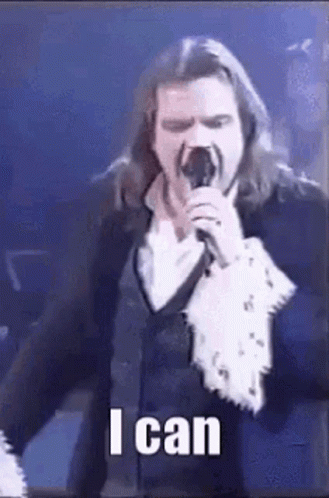 Man With Long Hair Singing Into Microphone GIF