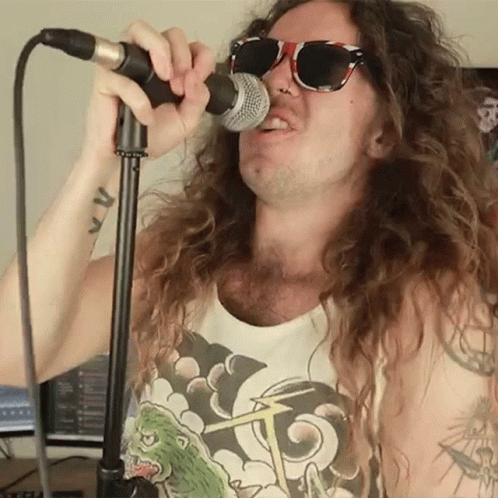 Man with Long Hair Singing into Microphone