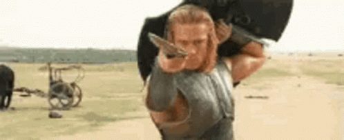 Man With Long Hair Sitting By Fence GIF