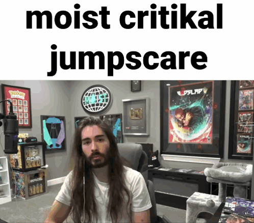 Man With Long Hair Sitting In Front Of Sign Saying Moist Critical Jumpscare GIF