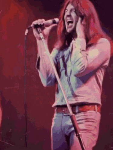 Man With Long Red Hair Singing Into Microphone