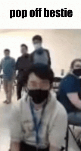 Man With Mask and Backpack on Head in Classroom