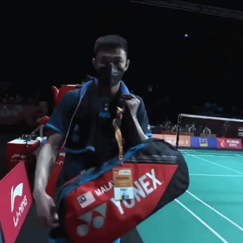 Man with Mask Carrying Yonex Bag