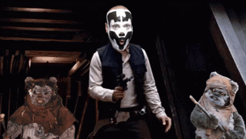Man with Mask Holding Gun Next to Ewok Bears