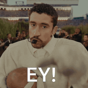 Man With Microphone in Mouth Holding Football Ey