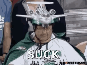 Man With Model Airplane Hat In Stadium GIF