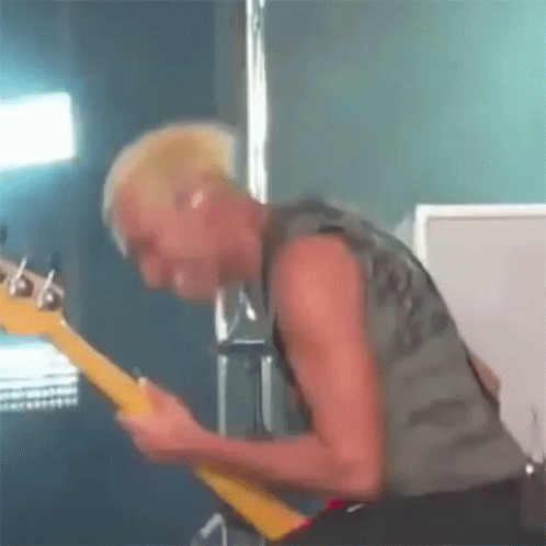 Man With Mohawk Playing Guitar on Stage