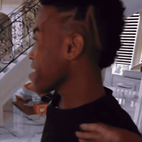 Man With Mohawk Standing by Window Blinds