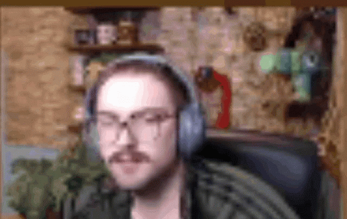 Man with Mustache and Glasses Wearing Headphones in Chair