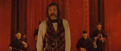 Man With Mustache Arms Outstretched on Stage