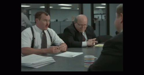 Man With Mustache At Table With Two Men In Suits
