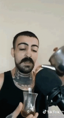 Man With Mustache Drinking From Glass With Spoon GIF