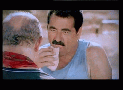 Man With Mustache Eating Sandwich From Another Man