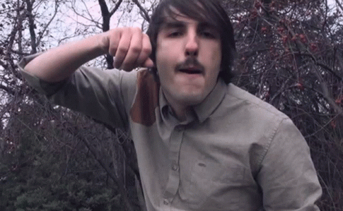 Man With Mustache Holding Knife To Face GIF