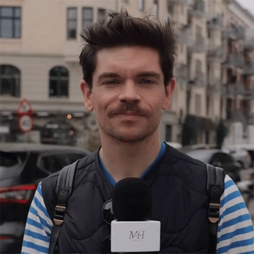 Man With Mustache Holding Microphone With MH