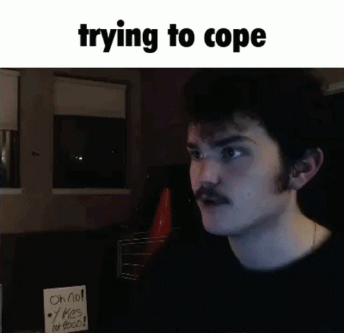Man with Mustache Holding Sign Saying Trying to Cope