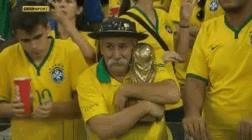 Man With Mustache Hugging Trophy in Crowd