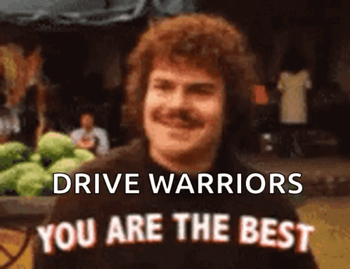 Man with Mustache in Front of Drive Warriors Sign