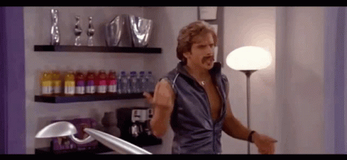 Man with Mustache in Room with Lamp and Bottles