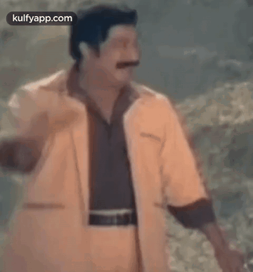 Man With Mustache in Yellow Jacket and Brown Shirt