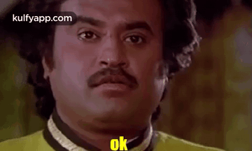 Man With Mustache in Yellow Shirt Making Funny Face Saying Ok