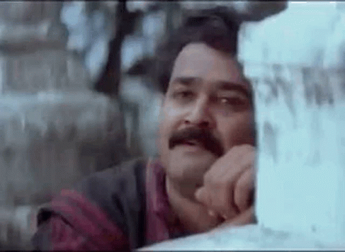 Man with Mustache Leaning Against Wall Gazing Out Window