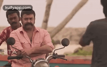 Man With Mustache Riding Motorcycle Beside Two Men