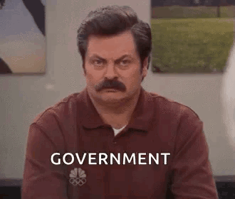 Man With Mustache Sitting In Front Of Government Wall GIF