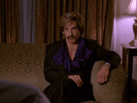 Man With Mustache Sitting on Couch Saying I Mean Come On