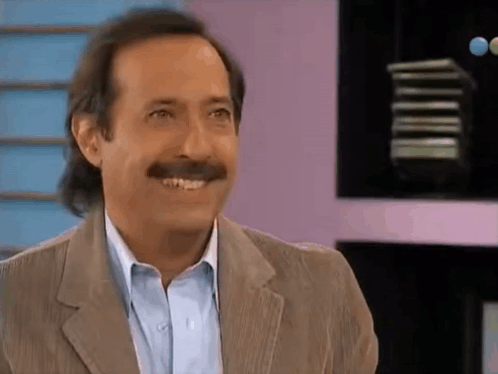 Man With Mustache Smiling in Suit and Blue Shirt