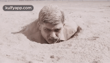Man With Mustache Sticking Head Out Of Sand Hole GIF