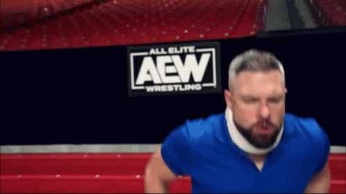Man with Neck Brace in Front of AEW Wrestling Sign