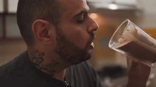 Man with Neck Tattoo Drinking from Cup