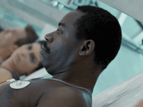 Man with Necklace Lying in Hospital Bed
