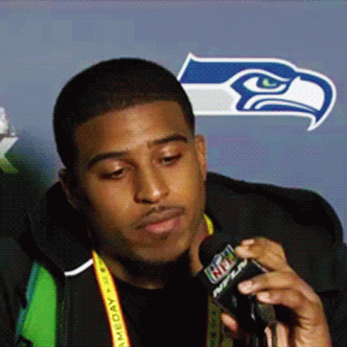 Man With NFL Lanyard Talking Into Microphone
