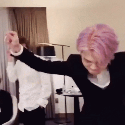 Man With Pink Hair Dancing While Another Man Watches