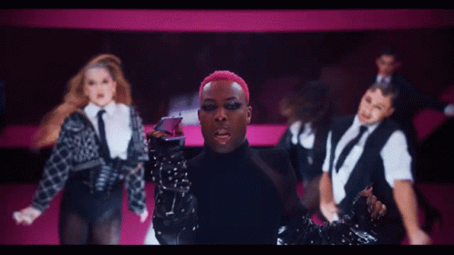 Man With Pink Hair In Front Of Female Dancers GIF