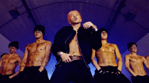 Man With Pink Hair in Front of Shirtless Men