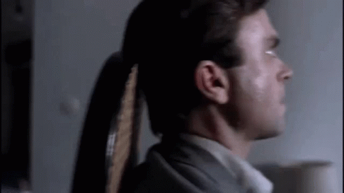 Man With Ponytail In Dark Room GIF