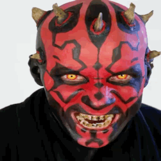 Man With Red Face Paint And Horns Smiling GIF