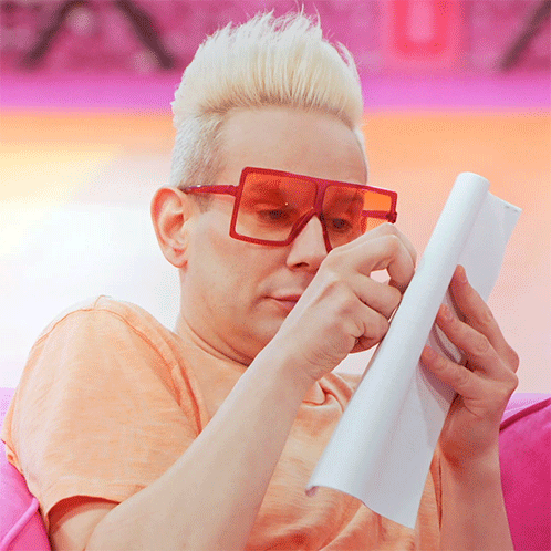 Man with Red Glasses Reading Paper