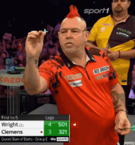 Man With Red Mohawk Holding Dart in Front of Sport1 Sign