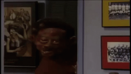 Man With Red Paint on Face Facing Picture Wall