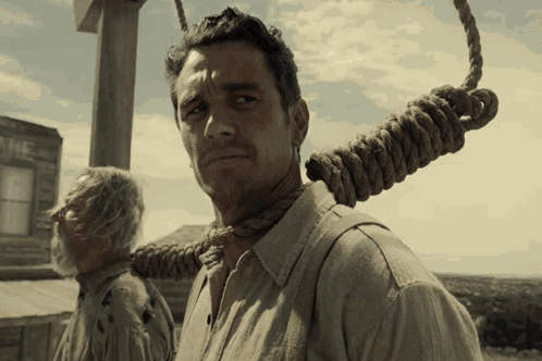 Man With Rope Around Neck Standing In Front Of Building Saying The GIF