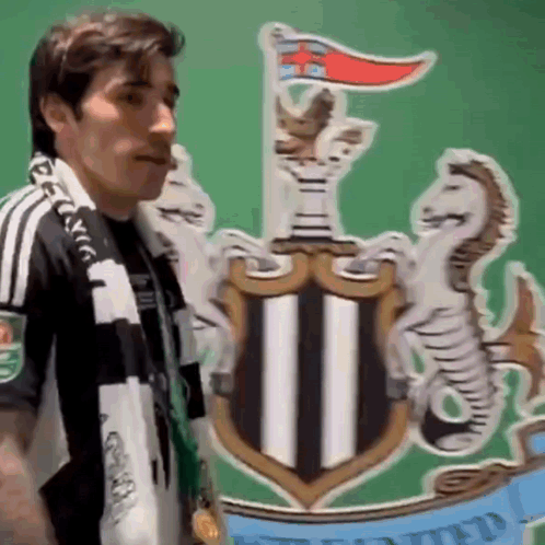 Man with Scarf in Front of Newcastle United Coat of Arms