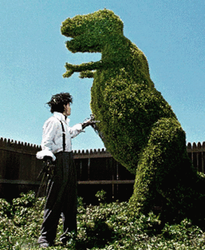 Man With Scissors Next to Dinosaur