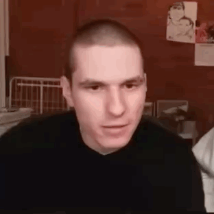 Man With Shaved Head in Black Sweater Looking at Camera