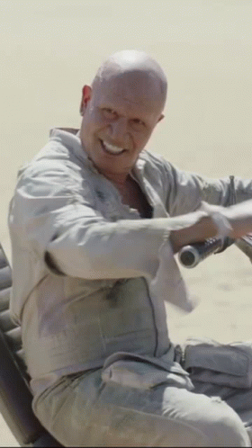 Man With Shaved Head Smiling Holding Steering Wheel