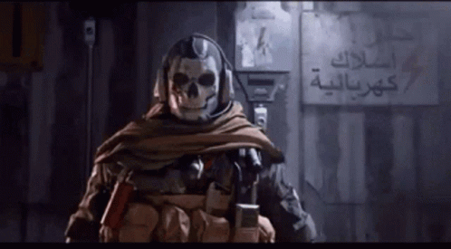 Man With Skull On Face In Front Of Wall With Arabic Writing GIF